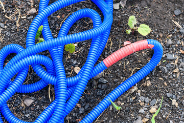 Broken blue water hose wrapped with duct tape