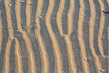 Grooves in sand, beaches and footsteps on the ground.