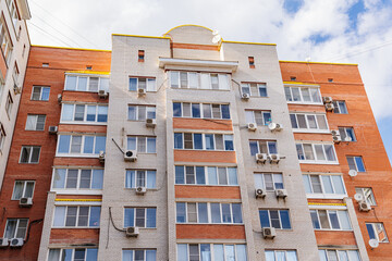 Fototapeta premium A typical brick multi-storey apartment building against the sky. 
