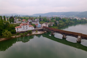 Aerial view of covered wooden bridge over the Rhine River at Stein, Canton Aargau, and Bad Säckingen, Baden-Württemberg, on a cloudy spring day. Photo taken May 6th, 2022, Stein, Switzerland.