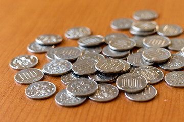 机の上に散らばる銀色の百円玉