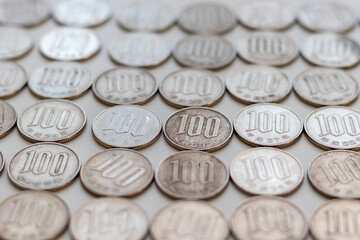 机の上に並べられた銀色の百円硬貨