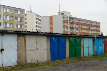 Fototapeta na wymiar Weathered garages by communist style prefabricated concrete apartment houses