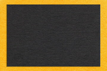 Fototapeta premium Texture of craft black paper background with yellow border, macro. Structure of vintage dense kraft cardboard