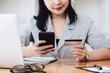 Fototapeta premium Online Shopping and Internet Payments, Asian man are using their credit card and mobile phone to shop online or conduct errands in the digital world.