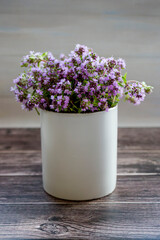 Fresh thyme flowers in a white cup. Fresh organic thyme flowers. Flowers of thyme creeping. Thyme. Phytotherapy. Selective focus.