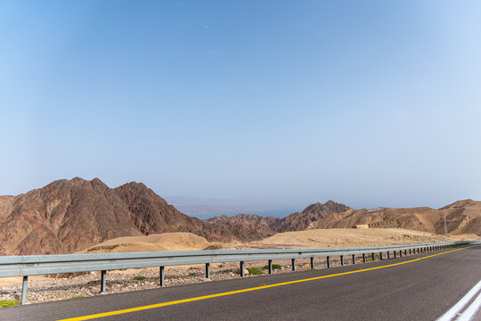 A road next to a mountainous desert landscape. Road 12 on the way to Eilat, Israel, on the Egyptian border. Mountains in different and varied sand colors. High quality photo