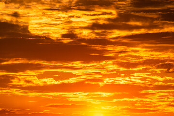 Die Sonne geht hinter einem bewölkten Himmel unter.