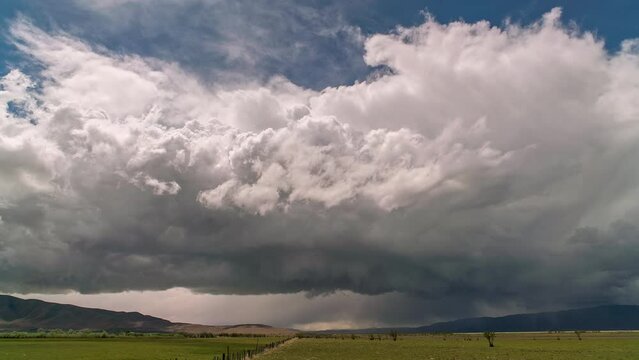 Thunderstorm rolling over the landscape towards and overhead through Utah Valley as rain and hail follows.