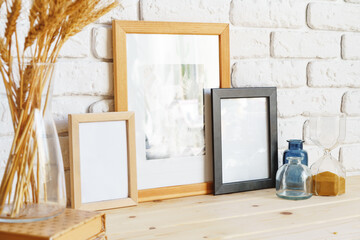 Photo frames on a brick wall background on the table with wheat ears in vase