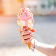 Cute girl eating ice cream on summer background outdoors. closeup portrait of adorable redhaired little girl eating ice cream.