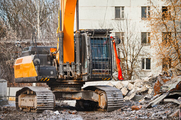 Fototapeta na wymiar Hydraulic excavator works with debris at demolition site