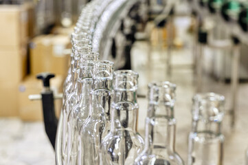 Production line transports empty glass bottles for alcohol