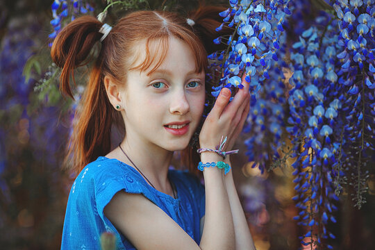Attractive redhaired teen portrait. Little girl with flowers.