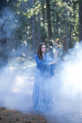Fototapeta premium Girl with a torch in the forest. The girl got lost in the forest. Torch.