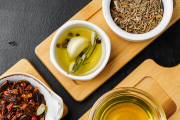 Oil, herbs and spices on wooden background