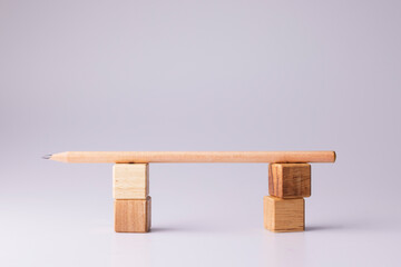 A wooden pencil placed on wooden dice is like a bridge or a door