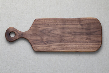  Walnut handmade wooden cutting board on burlap background.