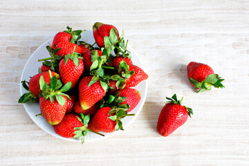 farm strawberries on white plate on beige background isolated, close-up