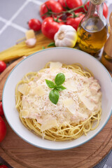 homemade pasta carbonara with fresh basil and parmesan in ceramic dish