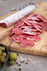 Sliced Spanish sausage fuet salami and vegetables on a domestic kitchen