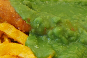 close up of English takeaway -  British mushy peas served with fish and chips 