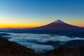 Fototapeta premium 夜明けの富士山と雲海 山梨県富士河口湖町新道峠にて