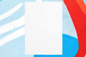 Closeup of colorful blue red white painted urban wall texture with wrinkled glued poster template....