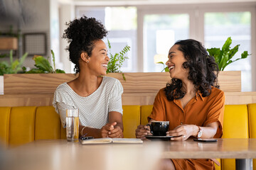 Happy smiling woman friends enjoying coffee in cafe