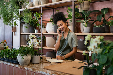 Florist takes an order on the phone at flower shop - obrazy, fototapety, plakaty