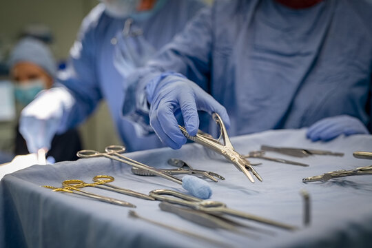 Surgeon hand taking surgical tools from tray
