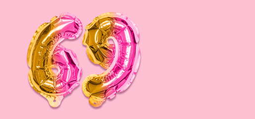 Rainbow foil balloon number, digit sixty nine on a pink background. Birthday greeting card with inscription 69. Top view. Numerical digit. Celebration event, template. Banner