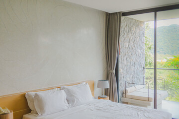 White stylish minimalist bedroom with summer landscape in window.