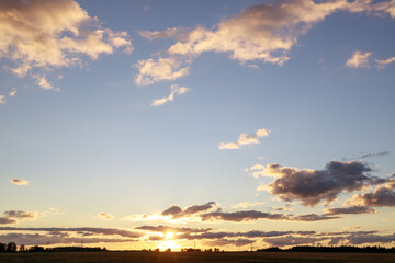 Fototapeta na wymiar morning sky with clouds skyline with sun and field