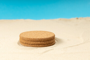 a round pedestal is set on the sand, an empty pedestal