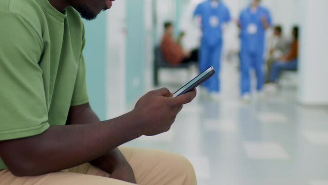 Patient waiting in hospital using smartphone