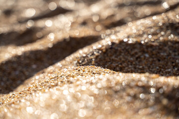 Golden sand on the coast at sunset with bokeh