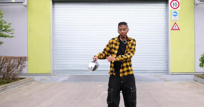 Young man with ghetto blaster dancing in front of garage gate