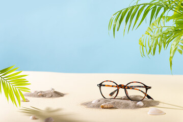 Trendy Eyeglass frame on a beach with palm leaves, trendy Still Life Style. Tortoiseshell frame...