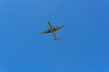 The plane is gaining altitude against the blue sky on a clear summer day