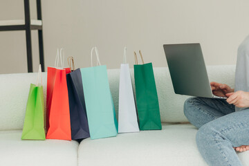 Close-up Of Woman Shopping Online Using Laptop With Colorful Shopping Bags
