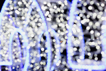 Festive background, blue and white lights of a Christmas garland on a dark background