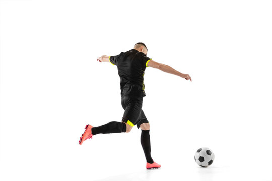 Rear view of professional male football soccer player in motion and action isolated on white studio background. Concept of sport, goals, competition, hobby, world cup