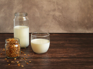 fermented milk product kefir in a glass jar with granola on a beige background