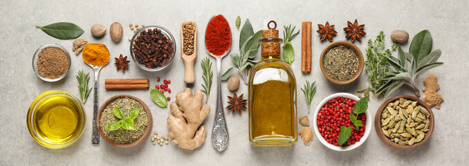 Different herbs and spices on grey table, flat lay. Banner design