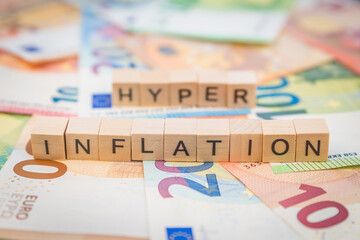 Das Wort Inflation und Hyper im Hintergrund auf Geldscheine Euro Euroscheine mit Holzwürfel...