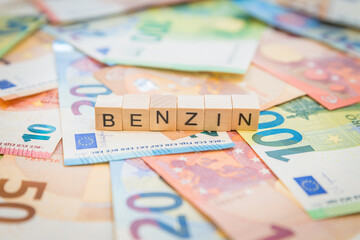 Das Wort Benzin – in deutsch für Benzin -  auf Geldscheine Euro Euroscheine mit Holzwürfel...
