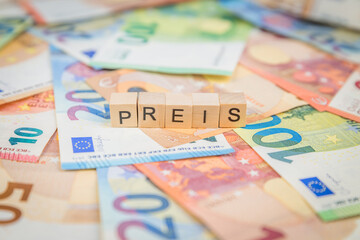 Das Wort Preis – in deutsch für Price -  auf Geldscheine Euro Euroscheine mit Holzwürfel...