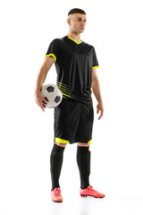 Professional male soccer player in black football kit posing with ball isolated on white studio background. Concept of sport, goals, competition, male hobby, occupations