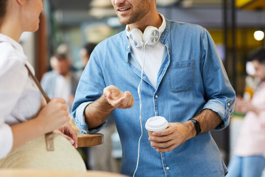 Close-up Of Student Boy With Stubble Wearing Blue Shirt Gesturing Hand And Telling Story To Girlfriend While Spending Time In Cafe